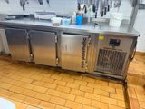 un plan de travail en acier inoxydable dans une cuisine, sur lequel sont posés tout un tas d'ustensiles