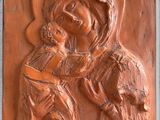 une image représentant une plaque sur laquelle figure une femme tenant un enfant dans ses bras