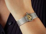 woman wearing a silver bracelet with a smiley face on it