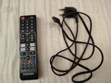 a remote control and a charger sitting on a bed