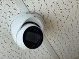 a white camera mounted on the ceiling of a building