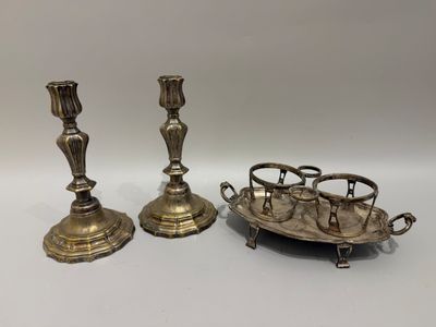 deux bougeoirs en argent et un plateau posés sur une table