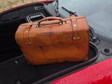 a suitcase sitting in the trunk of a red car