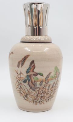 un petit vase avec un oiseau sur une surface blanche