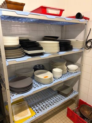 beaucoup d'assiettes et de casseroles sur les étagères de la cuisine