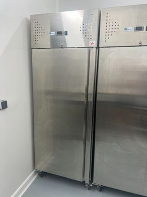 two stainless steel refrigerators side by side in a room