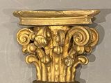 une sculpture en or accrochée au mur, à côté d'une horloge