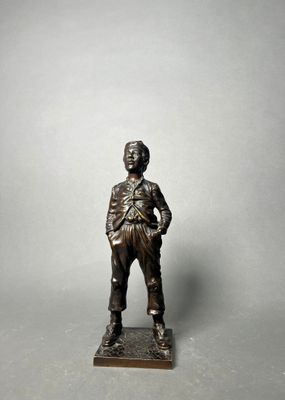 bronze figurine of a man standing on a base with his hands on his hips
