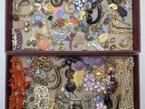 une boîte en bois remplie de bijoux variés, posée sur une table