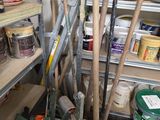 Plusieurs seaux de peinture et des outils sont posés sur une étagère