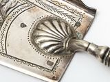 a silver plate with a handle on a white table