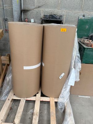 deux rouleaux de carton posés sur une palette dans un entrepôt