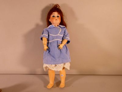 une image représentant une poupée vêtue d'une robe bleue et de bottes jaunes