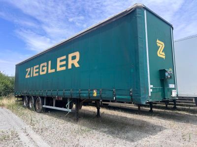 une semi-remorque verte garée sur le bord de la route
