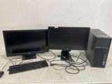 Deux écrans d'ordinateur et un clavier sont posés sur une table