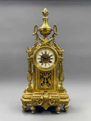 a gold clock sitting on top of a table