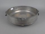 a silver plate with a handle on a gray background