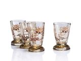 three shot glasses sitting on top of each other in front of a white background