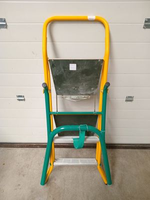 un tabouret vert et jaune sur lequel est posé un seau vert
