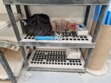 une étagère métallique sur laquelle sont posés divers objets, dans une pièce