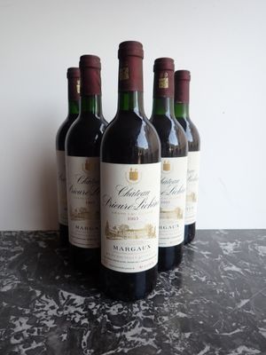 quatre bouteilles de vin rouge sont alignées sur une table