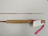 an old fishing rod with a pink ribbon attached to it