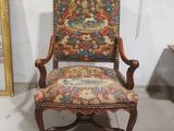 une vieille chaise dont le dossier est recouvert d'un tissu coloré et l'assise d'un tissu à motifs floraux