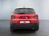 the rear end of a red citrole parked in a white room