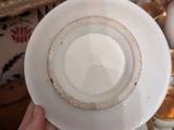 a person holding a white plate with a gold rim