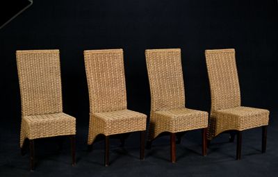 trois chaises en osier sont alignées devant un fond noir