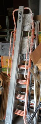 Des cartons et des échelles sont empilés les uns sur les autres dans un garage