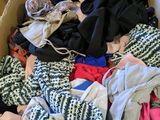 une boîte en carton pleine de vêtements posée sur le sol