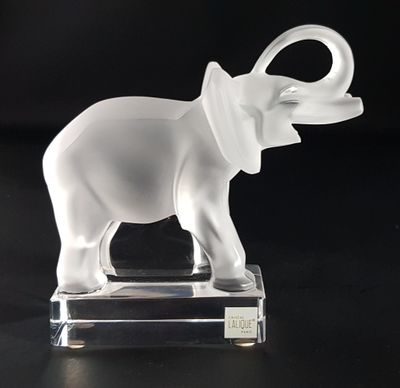 a glass elephant that is standing on a clear base