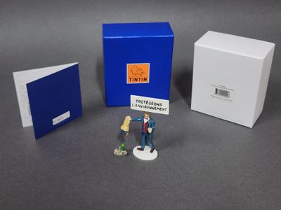 deux figurines représentant un homme et une femme debout devant une cabine téléphonique bleue