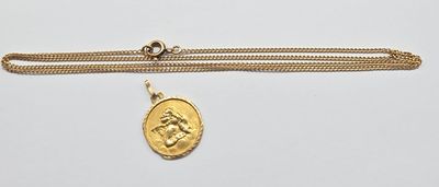 un collier en or avec une pièce de monnaie sur une chaîne