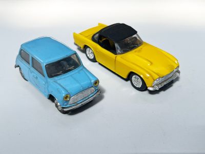 deux voitures jouets assises l'une à côté de l'autre sur une surface blanche