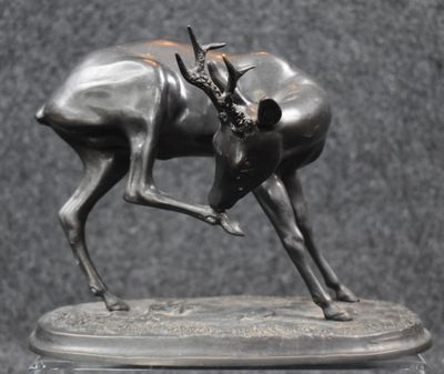 sculpture of antelope standing on a marble base on a black background