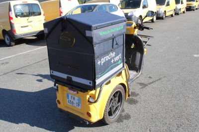 a small yellow motorcycle with a box on the back of it