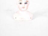 a small white doll with a hat on it ' s head
