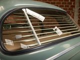 a green car with a window that has blinds on it