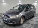 La camionnette grise est garée dans le garage, sur un sol à damier.