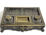 a black and gold desk with a gold tray on top of it
