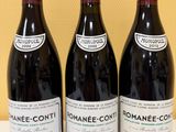three bottles of wine are lined up on a table