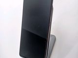 the back of a black cell phone sitting on top of a white table