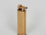 un briquet doré posé sur une surface blanche