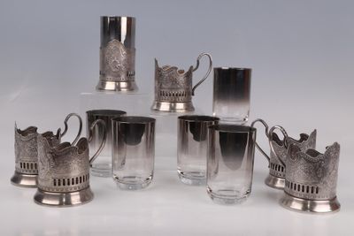 six tasses en métal argenté ornées de couronnes, posées sur un fond blanc