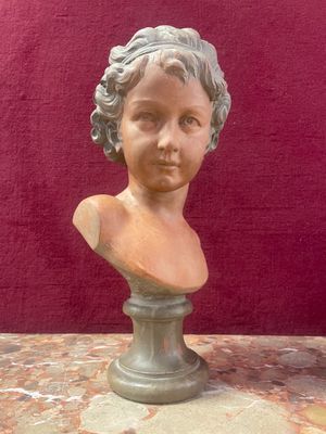 marble bust of a woman with curly hair on a pedestal