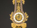 a gold clock on a marble table with a black background