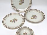 three plates and a bowl are sitting on a white surface