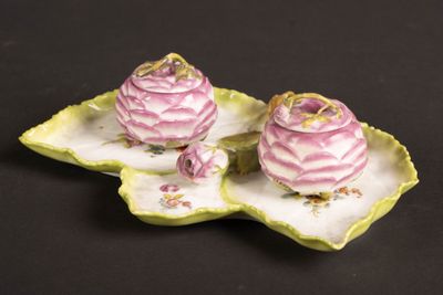 deux petites fleurs roses sur une assiette en forme de feuille verte